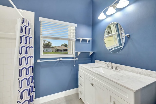 bathroom featuring curtained shower, vanity, and baseboards