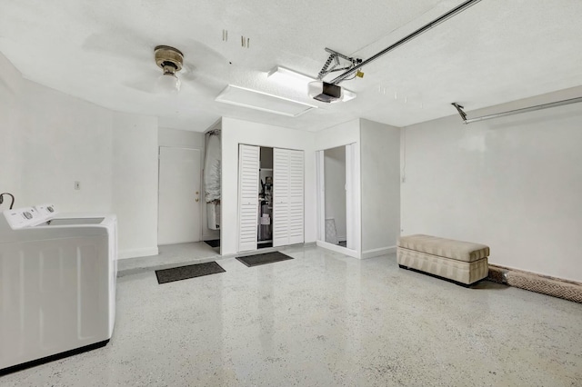 garage with a garage door opener, washing machine and dryer, and baseboards