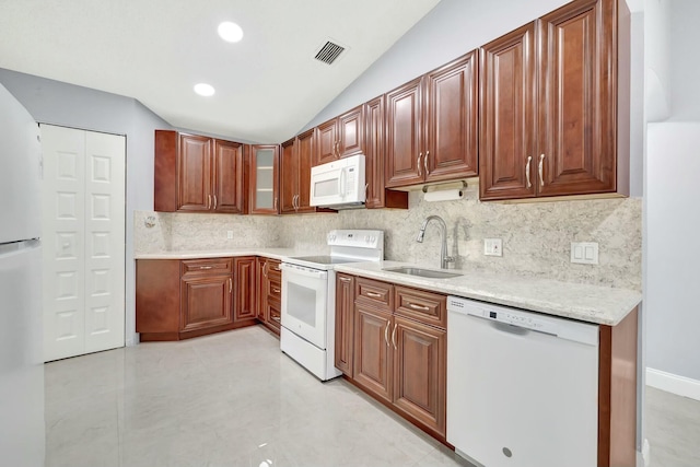 kitchen with lofted ceiling, light countertops, visible vents, a sink, and white appliances