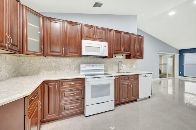 kitchen featuring lofted ceiling, light countertops, white appliances, and a sink