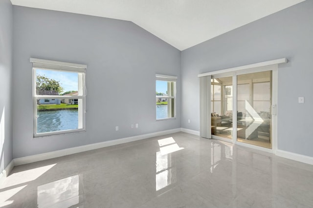 spare room with lofted ceiling, marble finish floor, and baseboards