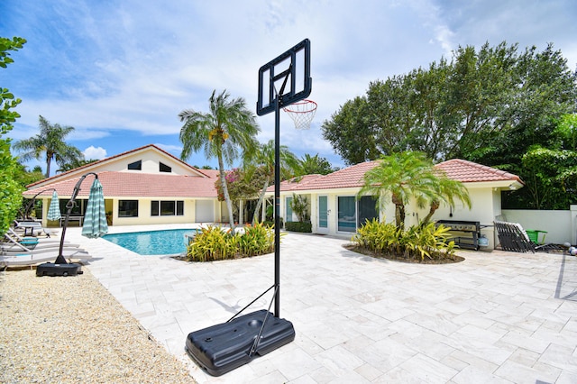 pool with french doors, a patio, and fence