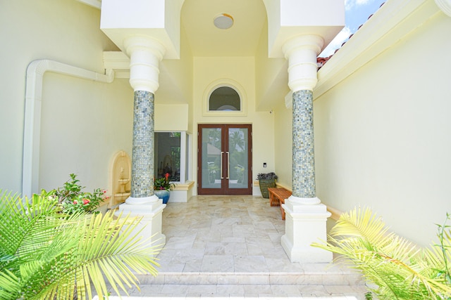 property entrance with stucco siding and french doors