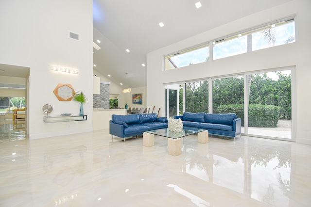 living area featuring a towering ceiling, baseboards, visible vents, and marble finish floor