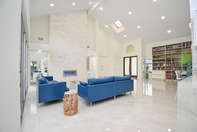 living area featuring visible vents, beamed ceiling, a skylight, and high vaulted ceiling