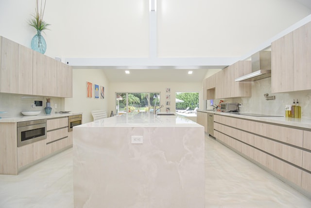 kitchen with light brown cabinetry, modern cabinets, wall chimney exhaust hood, and tasteful backsplash