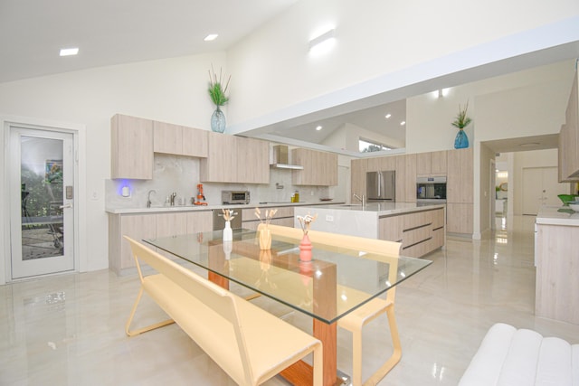 kitchen with a sink, wall chimney exhaust hood, modern cabinets, and light brown cabinetry