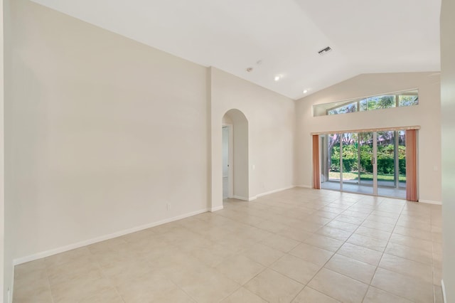 spare room with arched walkways, high vaulted ceiling, visible vents, and baseboards