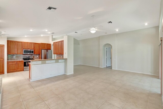 kitchen with tasteful backsplash, visible vents, appliances with stainless steel finishes, open floor plan, and ceiling fan