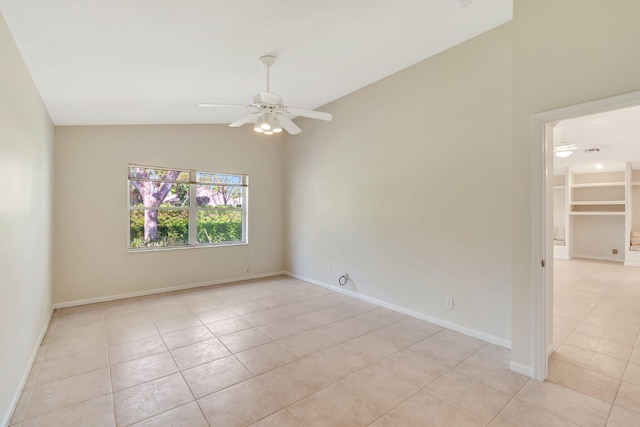 empty room featuring vaulted ceiling, light tile patterned floors, a ceiling fan, and baseboards