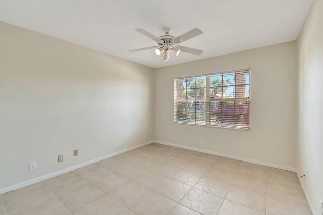 unfurnished room with ceiling fan, baseboards, and light tile patterned floors