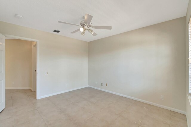 unfurnished room with ceiling fan, visible vents, and baseboards