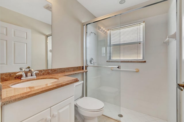 bathroom with toilet, a shower stall, visible vents, and vanity