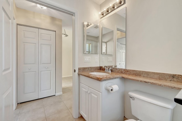 bathroom with vanity, a closet, tile patterned flooring, and toilet