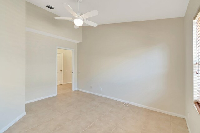 spare room featuring a ceiling fan, vaulted ceiling, and baseboards