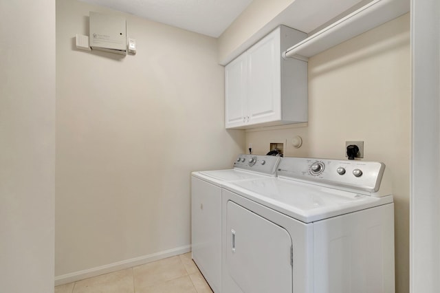 washroom featuring cabinet space, light tile patterned floors, baseboards, and independent washer and dryer