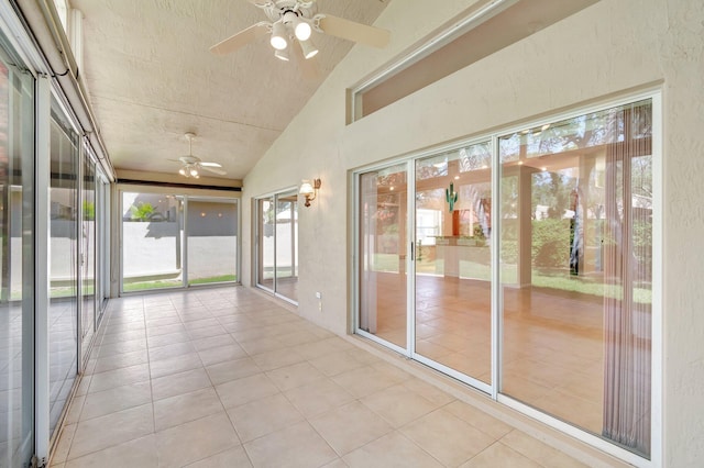 unfurnished sunroom featuring vaulted ceiling and a ceiling fan