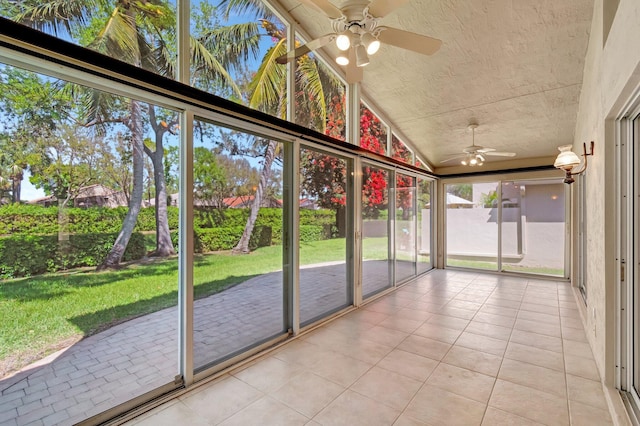 unfurnished sunroom featuring ceiling fan and vaulted ceiling