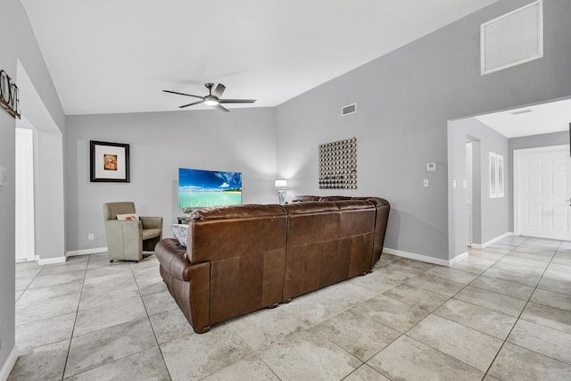 living area with visible vents, baseboards, ceiling fan, and vaulted ceiling