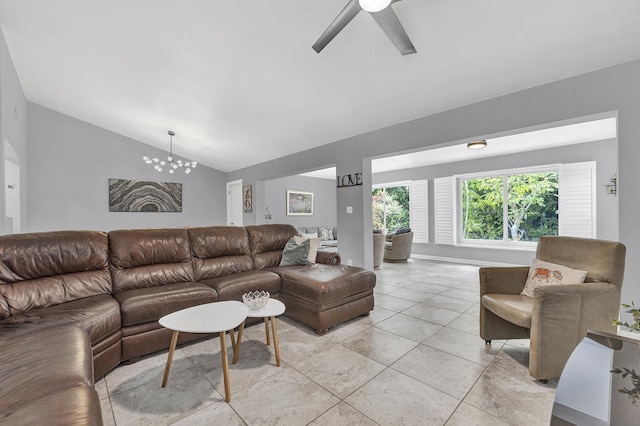 living room with lofted ceiling, light tile patterned flooring, and ceiling fan with notable chandelier