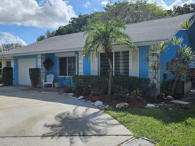 single story home with a garage, driveway, and a shingled roof