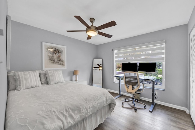 bedroom featuring wood finished floors, baseboards, and ceiling fan