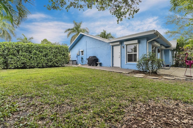 view of front of property with a front yard and stucco siding