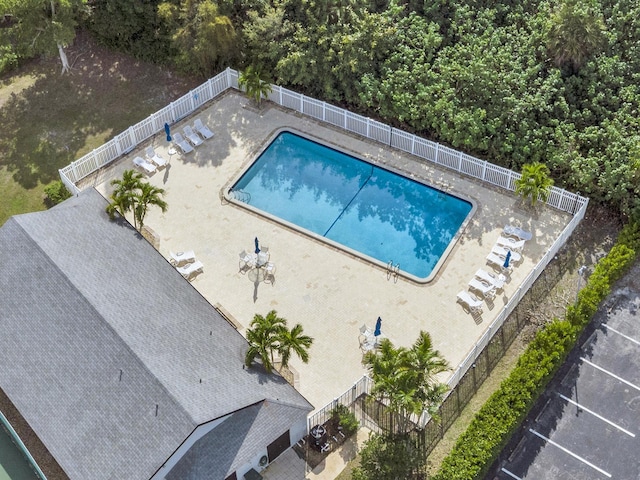 community pool with a patio and a fenced backyard