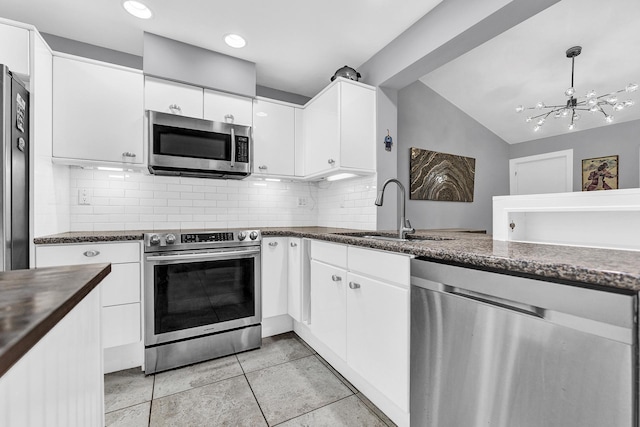 kitchen with a sink, stainless steel appliances, decorative backsplash, and white cabinetry