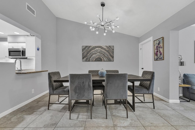dining room featuring visible vents, an inviting chandelier, light tile patterned flooring, baseboards, and vaulted ceiling