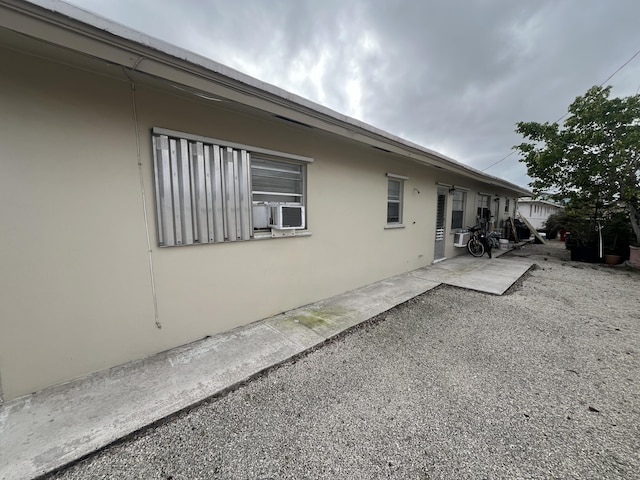 view of property exterior featuring cooling unit, a patio, and stucco siding