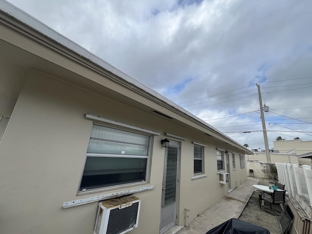 view of property exterior featuring a patio area, fence, and stucco siding