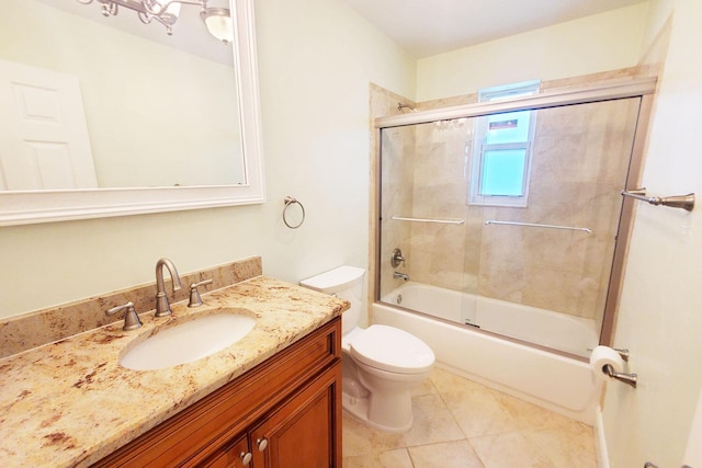 full bath with vanity, bath / shower combo with glass door, tile patterned flooring, and toilet