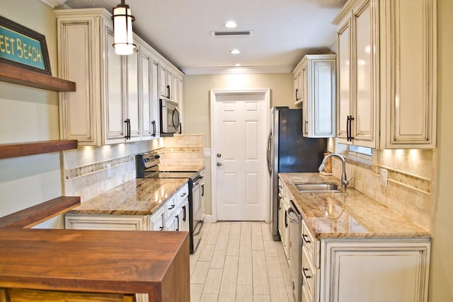 kitchen with open shelves, stainless steel appliances, visible vents, cream cabinets, and a sink