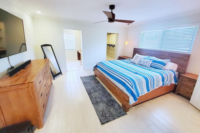 bedroom with a ceiling fan, light wood-type flooring, crown molding, and baseboards