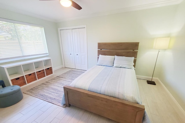 bedroom featuring a closet, wood finished floors, a ceiling fan, and baseboards