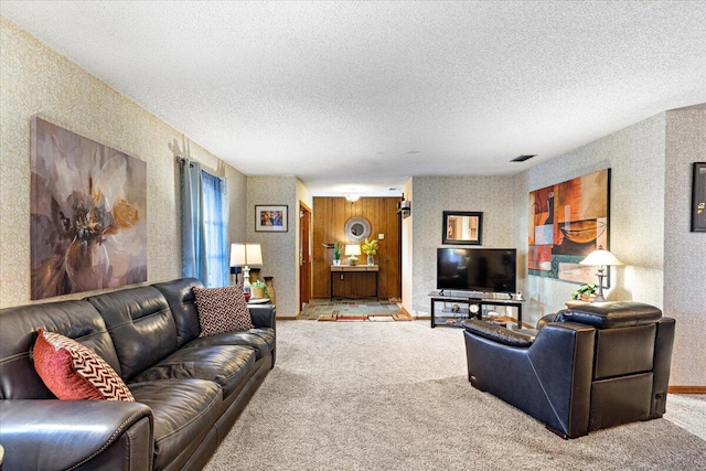 living area featuring visible vents, baseboards, a textured ceiling, and carpet flooring