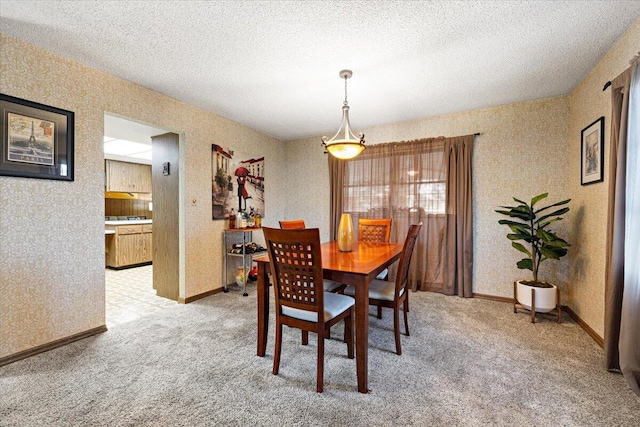 dining area featuring a textured ceiling, light colored carpet, and wallpapered walls