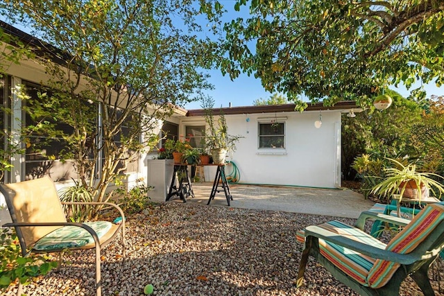 rear view of property with a patio and stucco siding