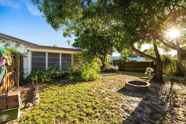 view of yard featuring a fire pit and fence