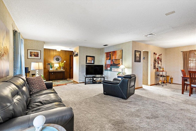 living area featuring carpet flooring, visible vents, and a textured ceiling