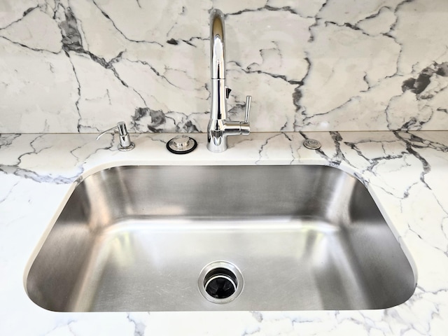 interior details featuring a sink and light stone countertops