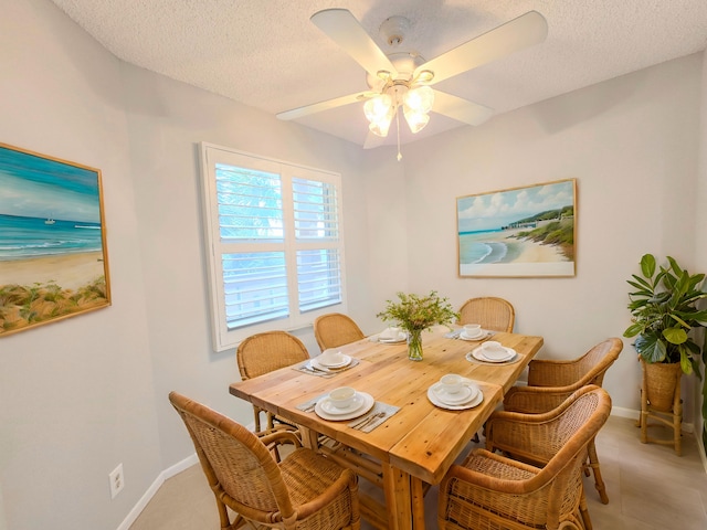 dining area with a textured ceiling, ceiling fan, and baseboards