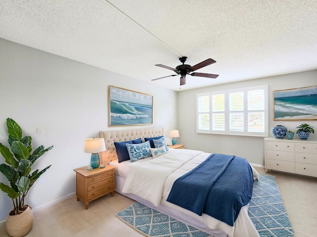 bedroom with a textured ceiling, a ceiling fan, and baseboards