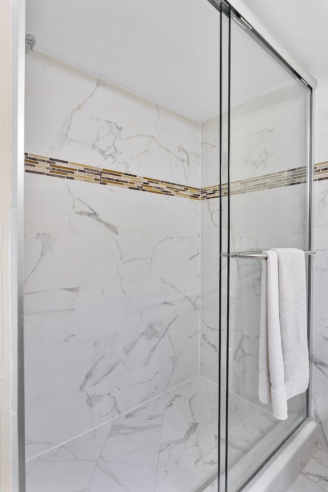 full bathroom featuring marble finish floor and a marble finish shower