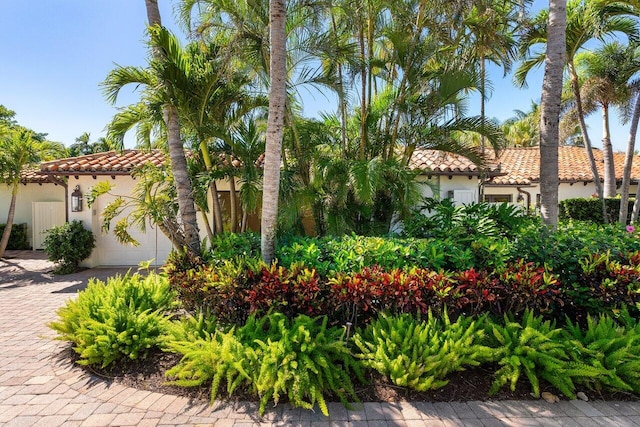 mediterranean / spanish home with a tile roof, decorative driveway, a garage, and stucco siding