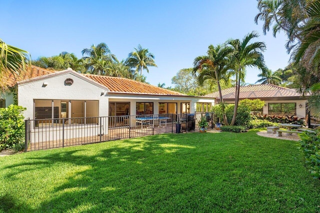 back of house featuring a patio, a lawn, a tile roof, and stucco siding