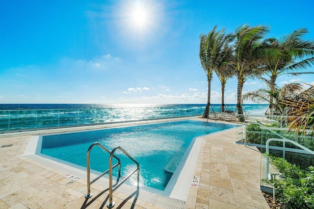 pool with a patio and a water view