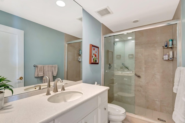 full bathroom featuring visible vents, a shower stall, toilet, and vanity