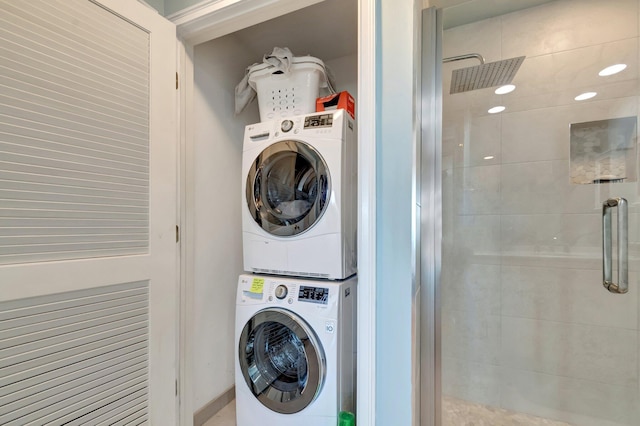 clothes washing area featuring stacked washing maching and dryer and laundry area